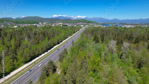 AERIAL: Flying along a wide highway leading towards the outskirts of Ljubljana.