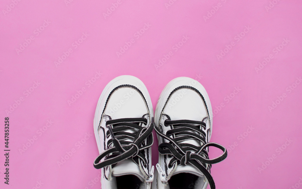 Children's shoes. Sports shoes, sneakers with laces on a pink background. The concept of a sports lifestyle. Flat space for copying. Layout. Flat top view, minimal copy space.