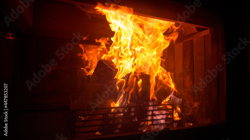 CLOSE UP: Idyllic shot of logs burning inside a firepit in a dark living room.