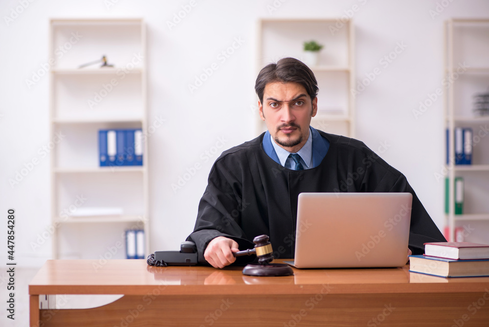 Young male judge working in the courtroom