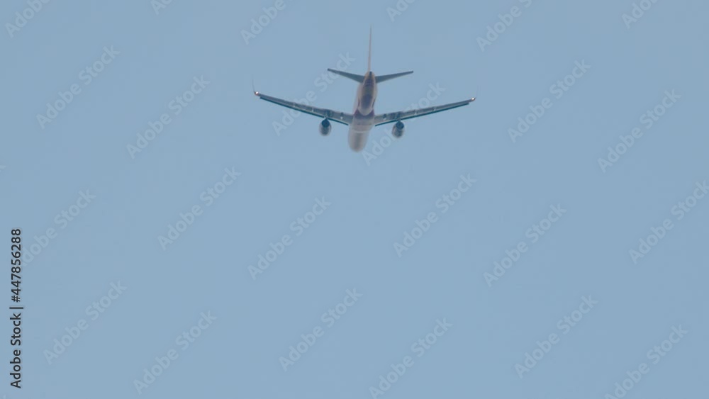 Large passenger plane takes off. View of airplane in the sky. Aircraft ascend. Plane taking off against blue sky. Slow motion Large passenger plane takes off. View of airplane in the sky. Aircraft ascend. Plane taking off against blue sky. Slow motion