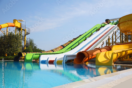 Beautiful view of water park with colorful slides and swimming pool on sunny day