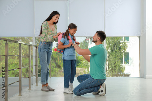 Parents saying goodbye to their daughter in school