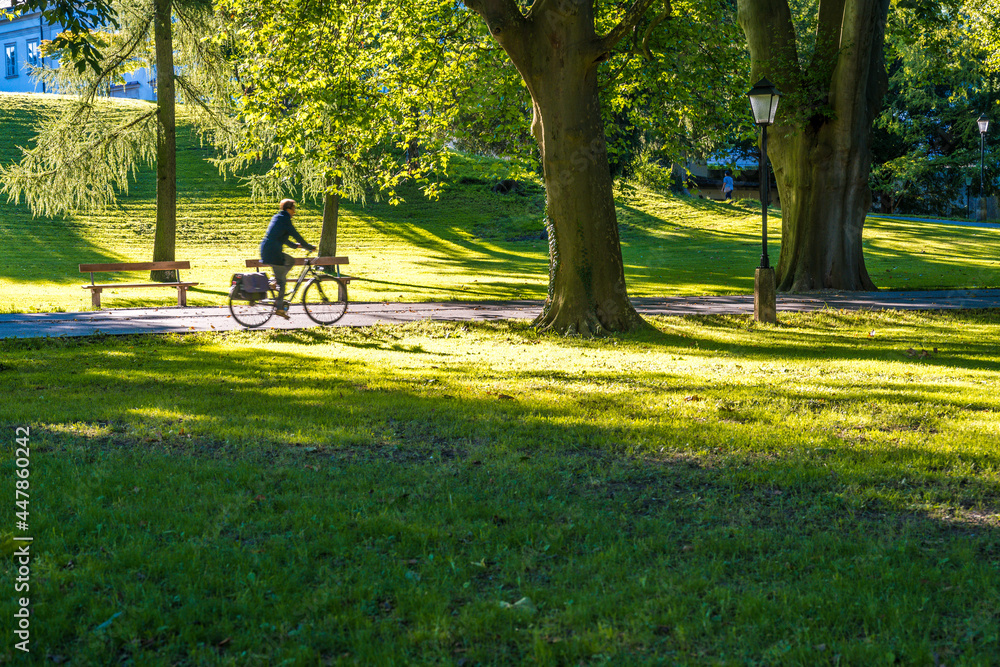 person riding bicycle in park - kurgarten Salzburg city person riding bicycle in park - kurgarten Salzburg city