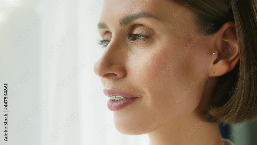 Young woman face close-up, female model with beautiful blue eyes looking in camera side view. Positive glance of businesswoman person, smile with braces on teeth. Young woman face close-up, female model with beautiful blue eyes looking in camera side view. Positive glance of businesswoman person, smile with braces on teeth.