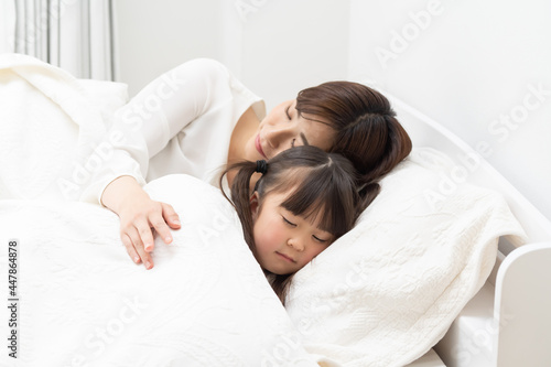 子供を寝かせる若い母親