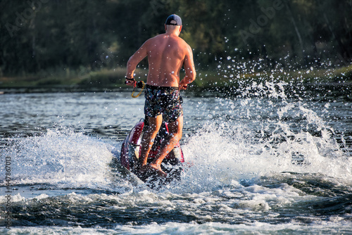 Fototapeta Naklejka Na Ścianę i Meble -  A man riding water scooter at sea on summer day.