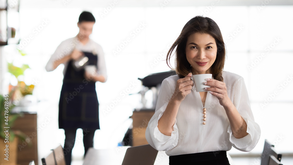 Smiling Business girl working with laptop. Happy Asian business woman hoding hand coffee at coffee cafe. young people with laptop Contact for work. Concept working in coffee cafe. Smiling Business girl working with laptop. Happy Asian business woman hoding hand coffee at coffee cafe. young people with laptop Contact for work. Concept working in coffee cafe.