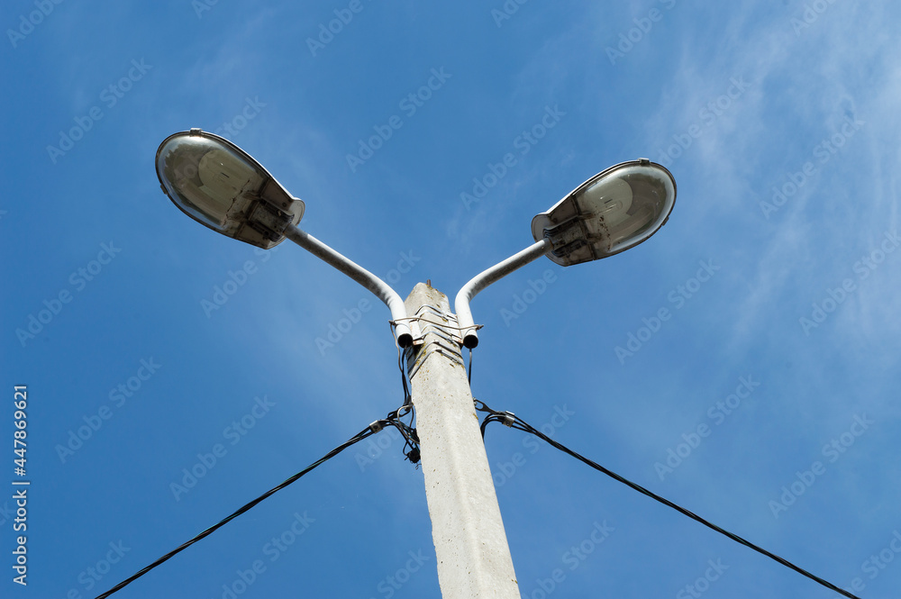 two street lights on a blue sky