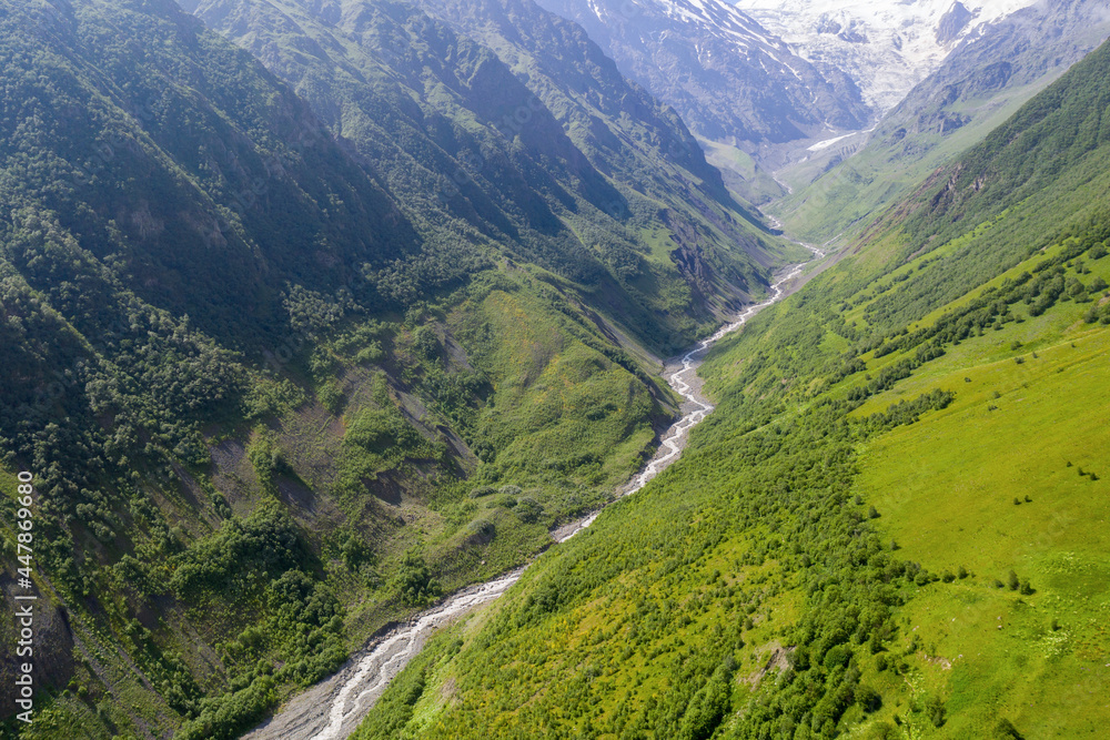 Fototapeta premium Aerial view of Genaldon river gorge and Mayly glacier on sunny summer day. North Ossetia–Alania, Caucasus, Russia.