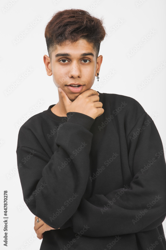 Vertical front-view portrait shot of a handsome young boy teenager in black long sleeve clothes looking at the camera and posing hand to the chin gesture in the studio with a white background Vertical front-view portrait shot of a handsome young boy teenager in black long sleeve clothes looking at the camera and posing hand to the chin gesture in the studio with a white background