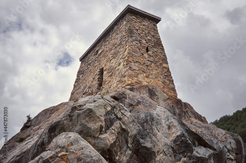 View of Amirkhan tower (17-18th centuries ) in Verhnyaya Balkaria village on cloudy summer day. Kabardino-Balkaria, Caucasus, Russia.