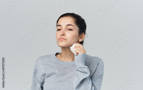 sick woman wiping face with handkerchief cold isolated background