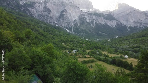 Theth National Park, Albania. Aerial view of albanian alps at sunrise. Flying over green trees overlooking the village of Thethi and majestic mountains. The Accursed Mountains in Albania Prokletije