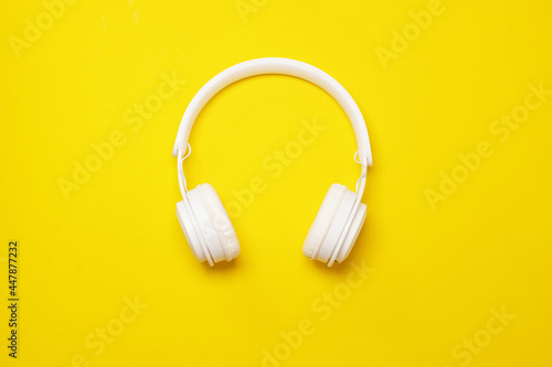 Modern white wireless headphones on a yellow background, Trendy minimal style.