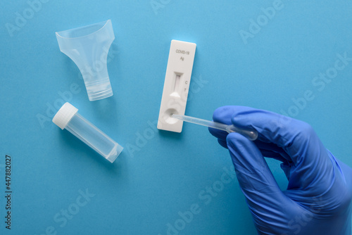 Valokuva Hand in protective glove making antigen covid test with pipette and saliva