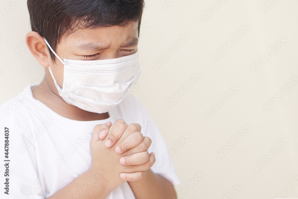 Little Asian boy praying and worship to GOD for stop spirituality and Surrender concept. Cover the mask to protect the germ or virus from the air. 2019-Corona virus or Covid-19. Little Asian boy praying and worship to GOD for stop spirituality and Surrender concept. Cover the mask to protect the germ or virus from the air. 2019-Corona virus or Covid-19.