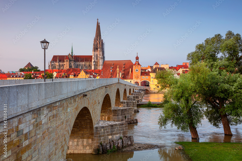 Regensburg, Germany. Cityscape image of Regensburg, Germany with Old Stone Bridge over Danube River and St. Peter Cathedral at summer sunrise.