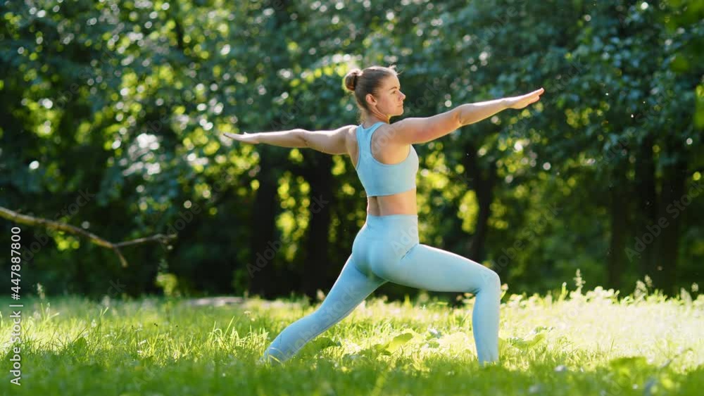 Young woman yoga trainer stands in static pose on meadow Young woman yoga trainer stands in static pose on meadow