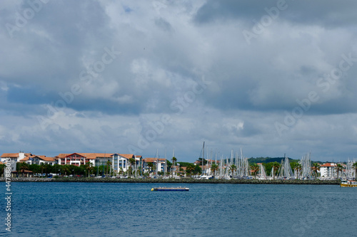 View on the French coastal town Hendaye from Spanish side. Sea border between Spain and France, dramatic grey cloudscape