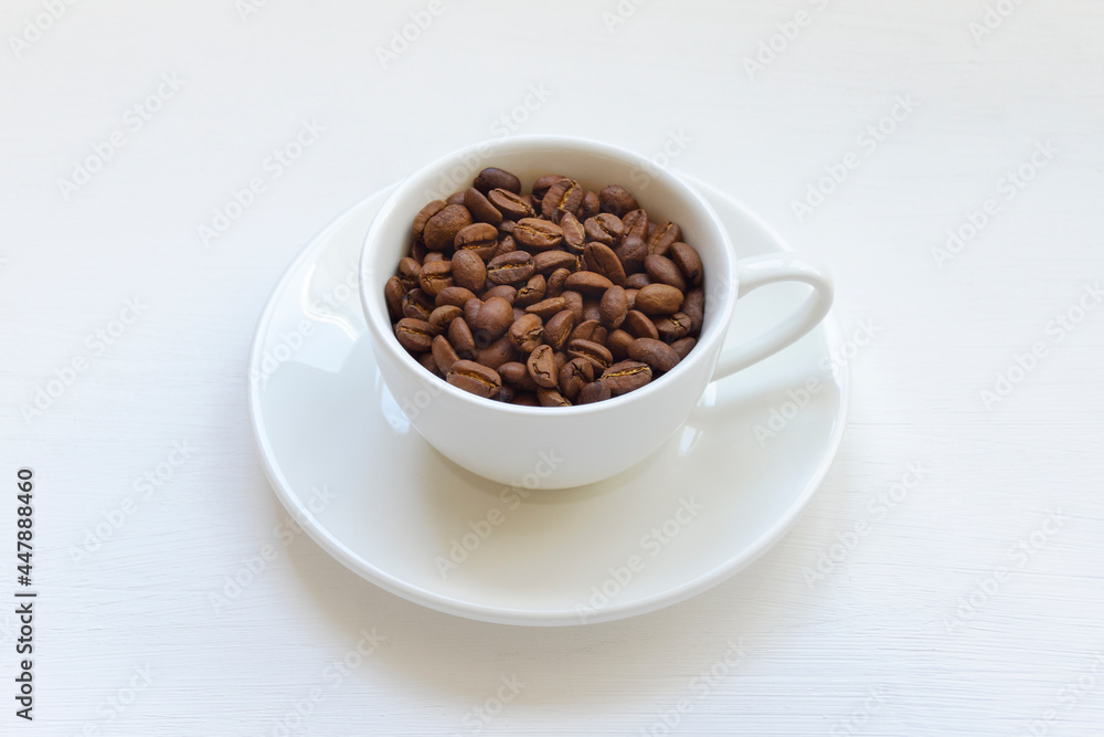Coffee beans in a white mug on the table Coffee beans in a white mug on the table