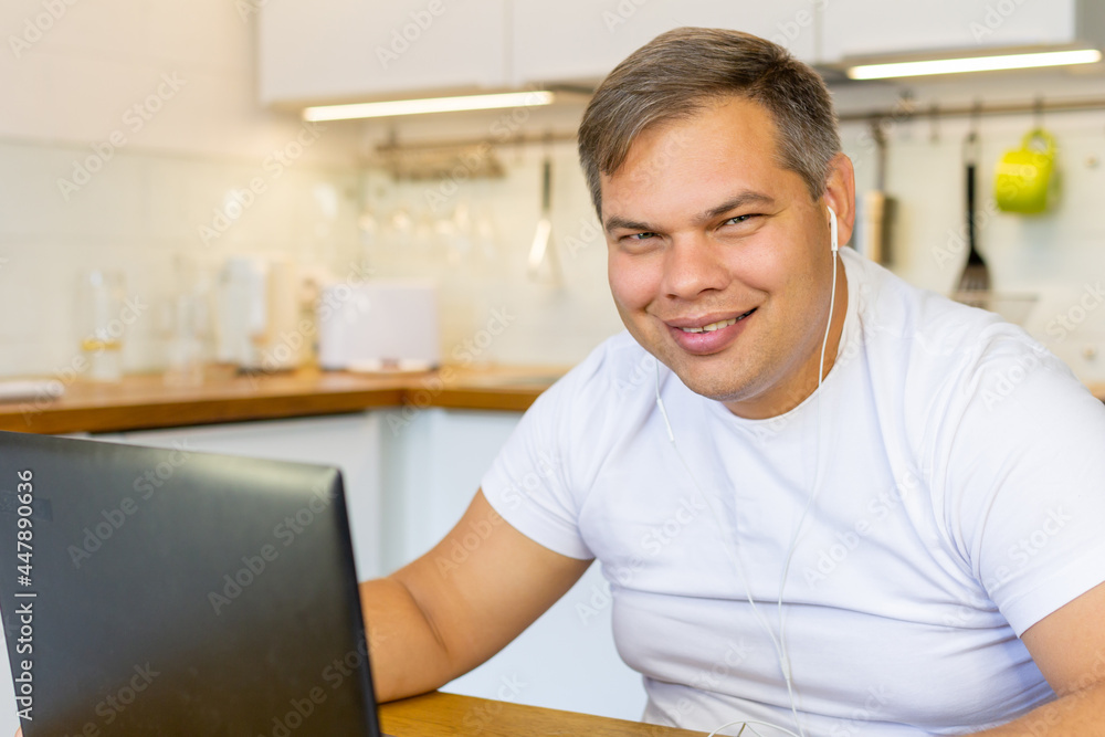 smiling European man working on laptop in his kitchen. home Office. businessman at home smiling European man working on laptop in his kitchen. home Office. businessman at home