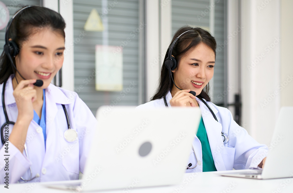 Asian female doctors waer headset and talking for take care patient with telecommunication online service Asian female doctors waer headset and talking for take care patient with telecommunication online service