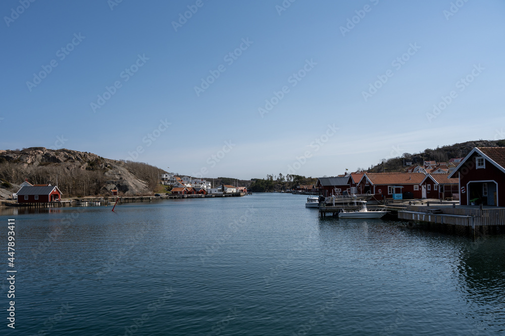 A picturesque fishing village on the Swedish West coast. Traditional red sea huts and a blue sky in the background