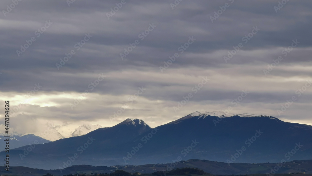 Nuvole grigie sopra le montagne innevate
