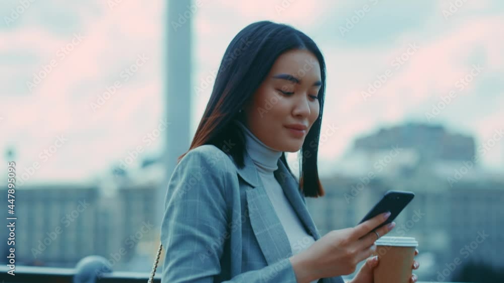 Young beautiful woman with coffee and street heading to work. Successful asian office manager female walking outside on the bridge. Young beautiful woman with coffee and street heading to work. Successful asian office manager female walking outside on the bridge.