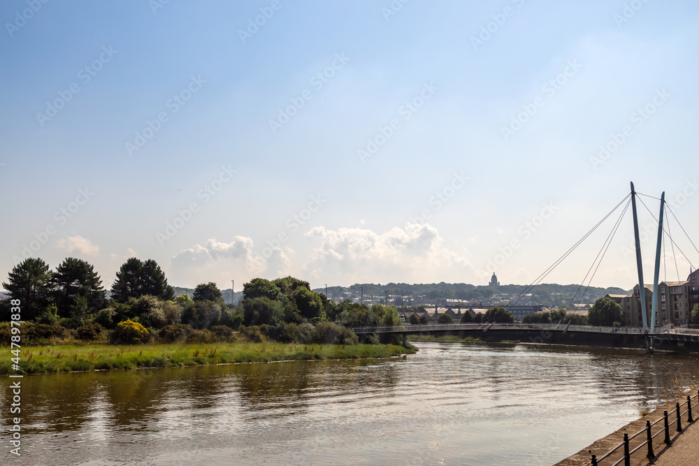 Fototapeta premium River Lune in Lancaster, UK with cable-stayed the Millennium Bridge in a background.