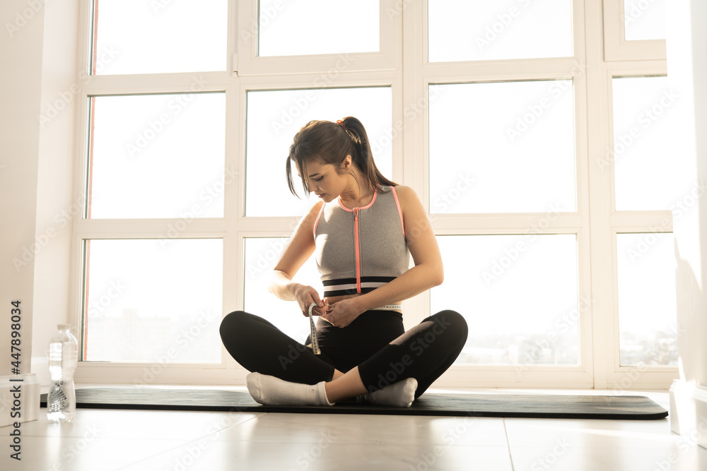 Sports woman measuring figure with measuring tape Sports woman measuring figure with measuring tape