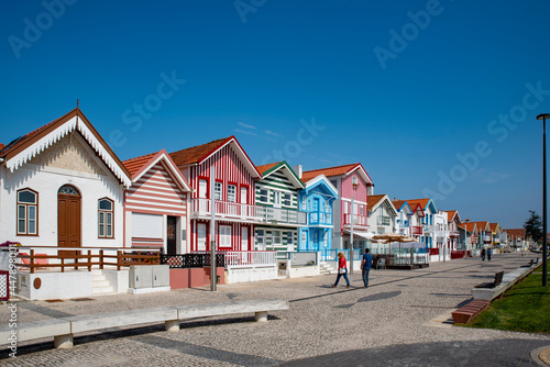 Street with colorful striped houses typical of Costa Nova, Aveiro, Portugal.