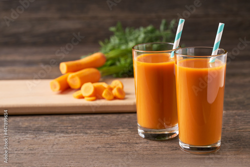 Fresh carrot juice in glasses on a  rustic wooden table, selective focus.