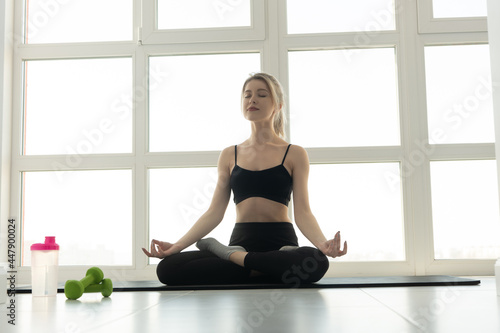 Sports woman practicing yoga on fitness mat