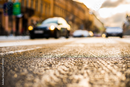 Bright winter sun in a big city, the car driving on the street. Close up view from the road level