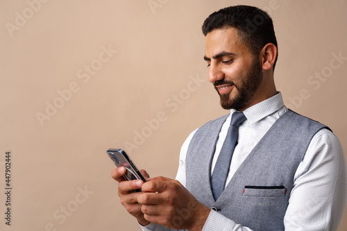Portrait of arab man using his smartphone in studio