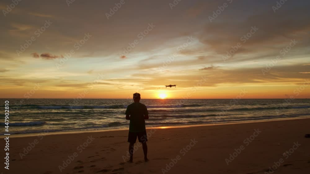 stunning colorful clouds in yellow sky at sunset..A man flying drone in stunning colorful yellow sky at sunset..Tourists piloting drones to take pictures of beautiful sunset. stunning colorful clouds in yellow sky at sunset..A man flying drone in stunning colorful yellow sky at sunset..Tourists piloting drones to take pictures of beautiful sunset.