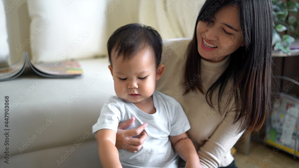 Young mother and little boy child reading book sitting on floor near sofa. Young mother and little boy child reading book sitting on floor near sofa.