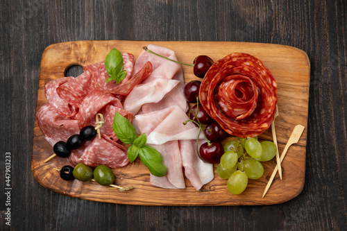 Salami, prosciutto ham, olives, cherry, grape. food snacks for an aperitif, a picnic, for a festive dinner or a party. 