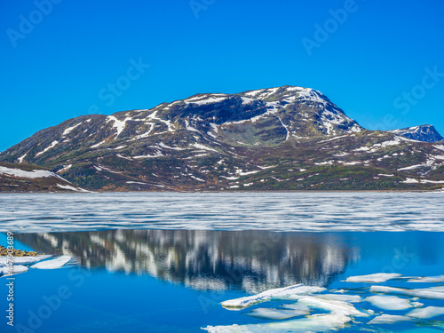 Frozen turquoise lake Vavatn panorama in summer landscape Hemsedal Norway. photo