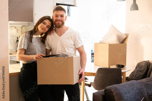 Portrait of couple holding box with things at home © Ivan