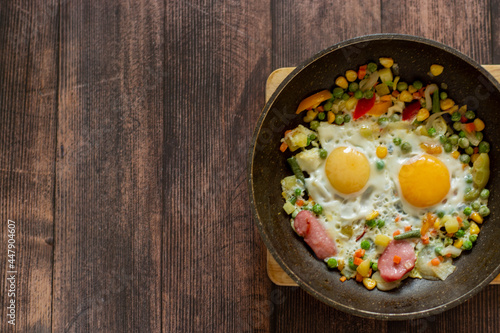 Brunch-fried eggs with vegetables in a frying pan