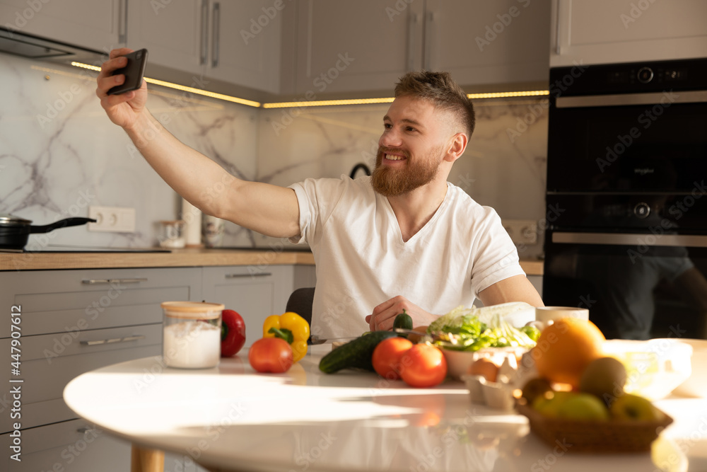 Young man take selfie on mobile phone at table Young man take selfie on mobile phone at table