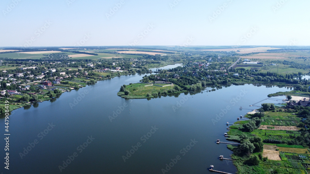 aerial view over the small village. Countryside on river coast. fields and gardens drone view. village by the river.