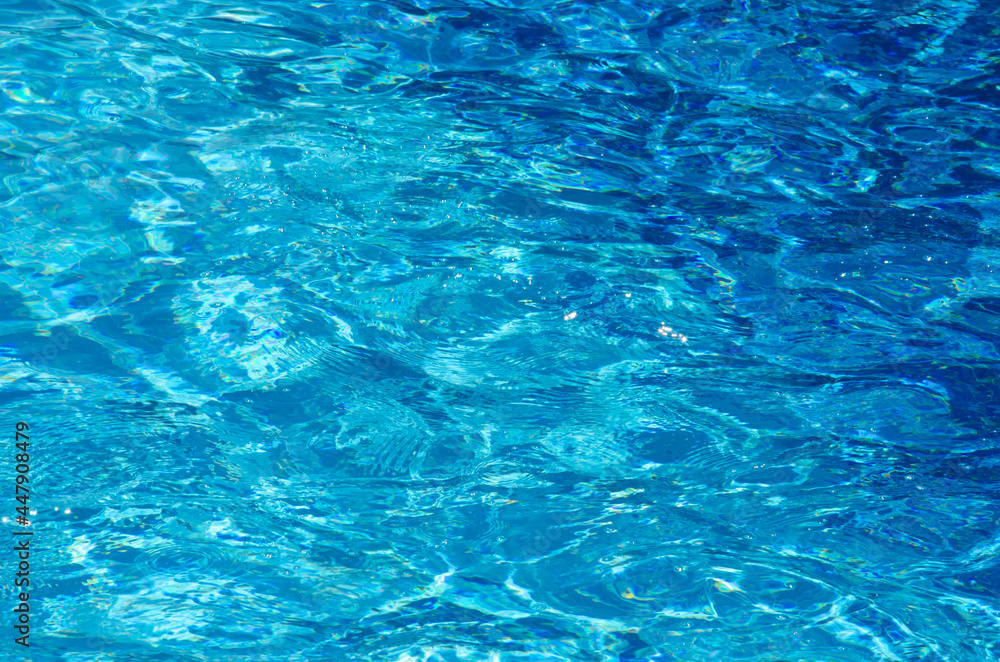 Top view rippled blue pool water with copy space. Surface of azure swimming pool. Hotel pool with sun reflections. Summer vacation concept. Top view rippled blue pool water with copy space. Surface of azure swimming pool. Hotel pool with sun reflections. Summer vacation concept.