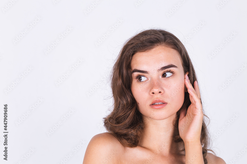 Young beautiful natural soft clean skin woman with freckles light makeup on white background with bare shoulders Young beautiful natural soft clean skin woman with freckles light makeup on white background with bare shoulders