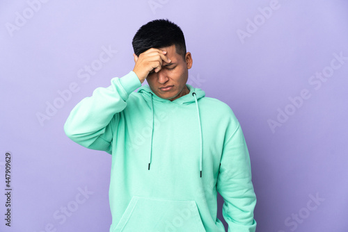 Young Ecuadorian man isolated on purple background with headache © luismolinero