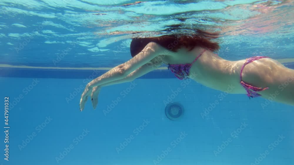 Tourist woman swim underwater at large wading pool, make wave movements and bend body, quickly pass by. Healthy exercise or recreation at hot summer day Tourist woman swim underwater at large wading pool, make wave movements and bend body, quickly pass by. Healthy exercise or recreation at hot summer day