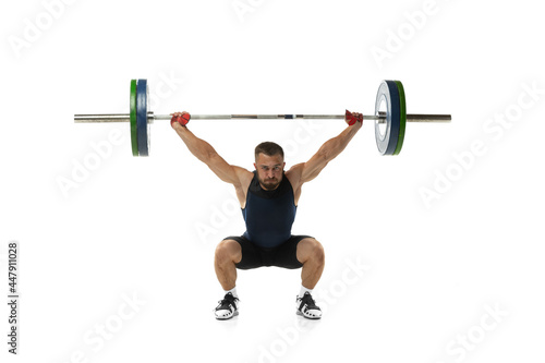 Full length portrait of a man in sportswear exercising with a weight isolated on white background